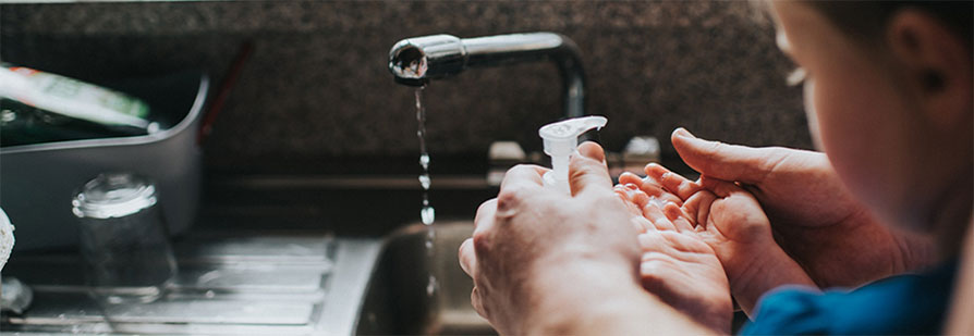 Parent showing child how to wash hands